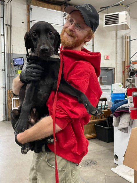 A man holding a black dog